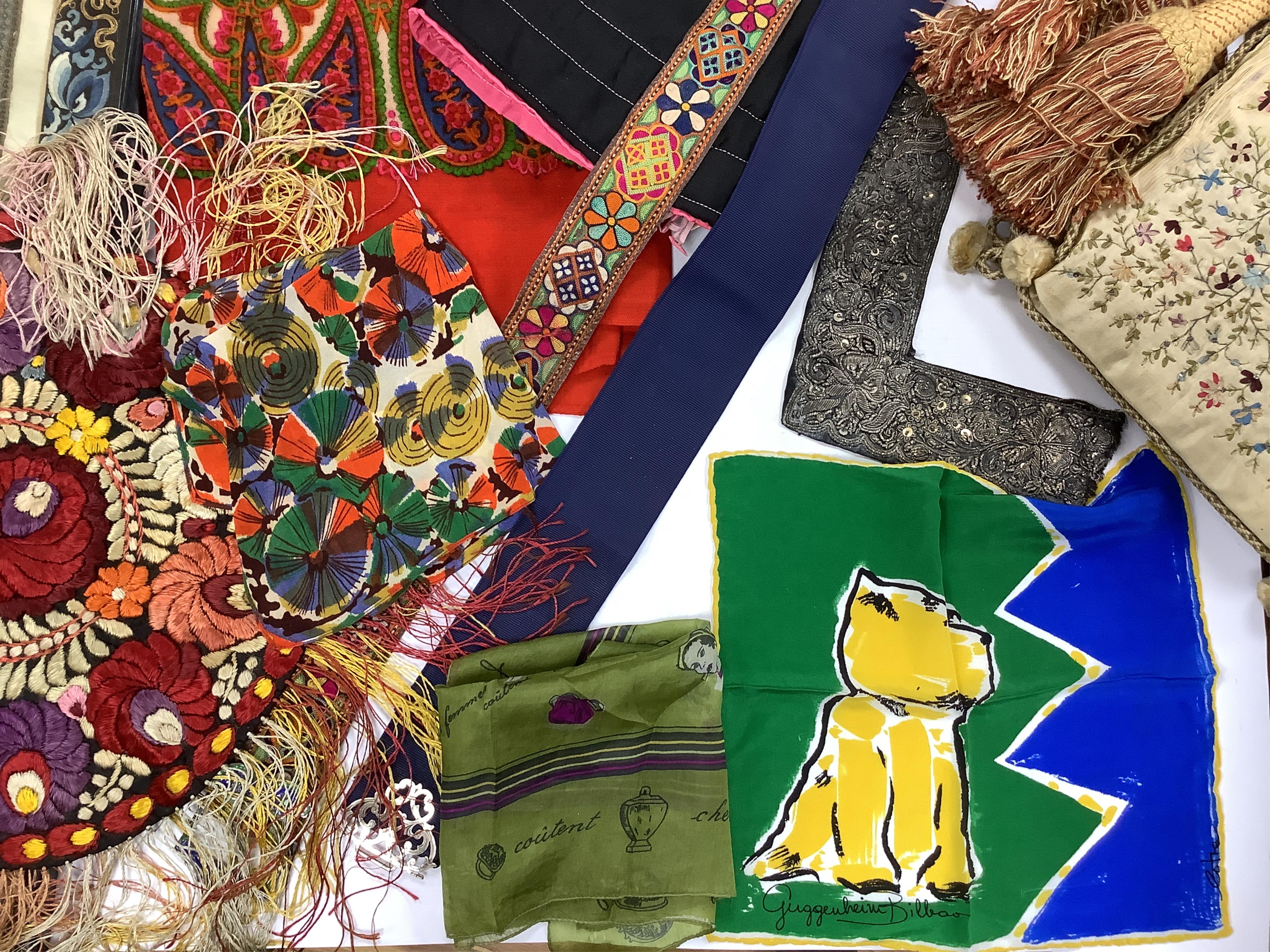 A collection of textiles: a ribbon work hankie and pyjama case, a metalwork collar, a coloured printed shawl, a nurses belt and embroidered belt, an advertising Guggenheim Bilbau hankie etc (10). Hankie case 22cm square.